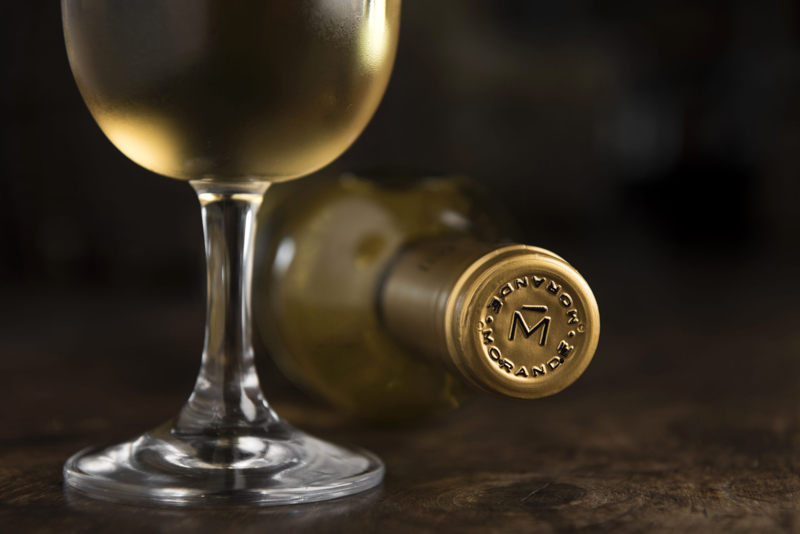 Morandé Late Harvest on a wine glass by a bottle lying down