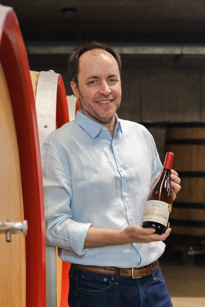winemaker ricardo baettig with bottle of vitis unica chardonnay